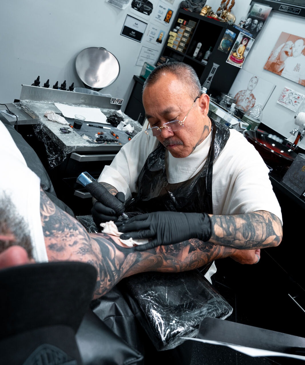 Robert Pho tattooing a black and grey realism piece