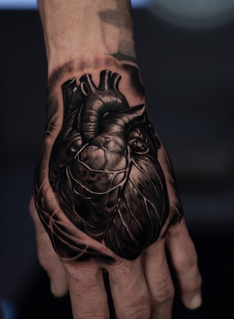 Black and grey realism anatomical heart hand tattoo by Robert Pho